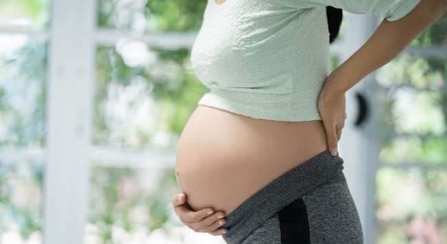 A pregnant woman holding her belly